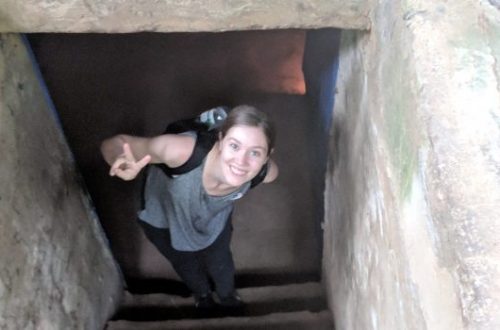 Thyra standing in one of the Cu Chi Tunnels giving the peace sign.